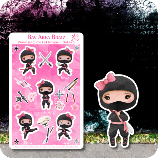 Sticker sheet of six chibi-style girl ninjas in black outfits with pink bows and belts, surrounded by flowers and ninja tools. Set on a pink background with cherry blossom accents, against a moody urban wall with purple-toned graffiti. Includes a large die-cut sticker of one girl ninja in a shy pose.
